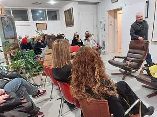 Un grupo de personas están sentadas en sillas en una habitación.