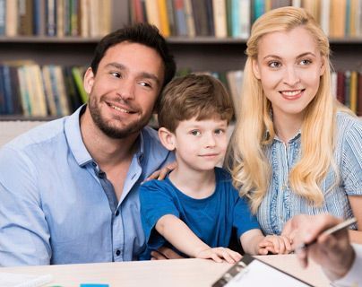 Una familia está sentada en una mesa con una tableta.