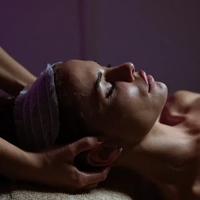 Una mujer con un vendaje en la cabeza está recibiendo un masaje.