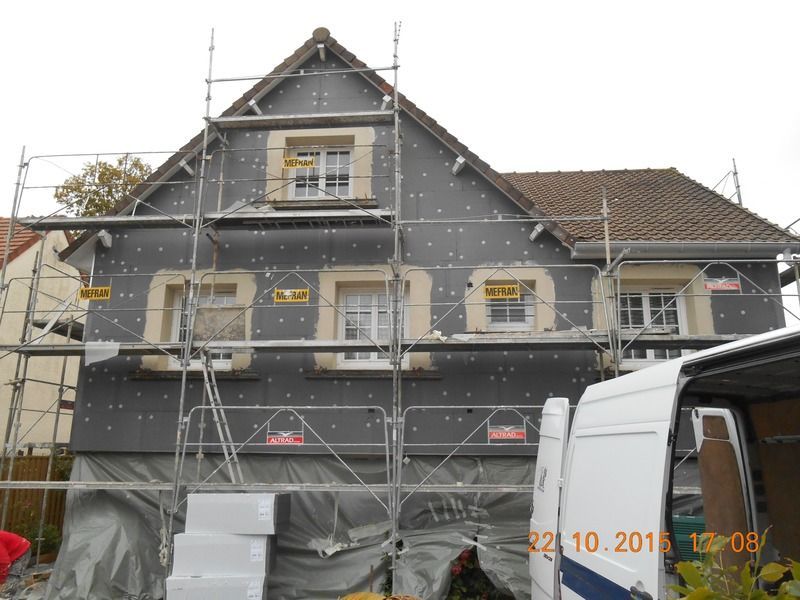 Pose d'isolant par l'extérieur d'une maison avec échafaudage.