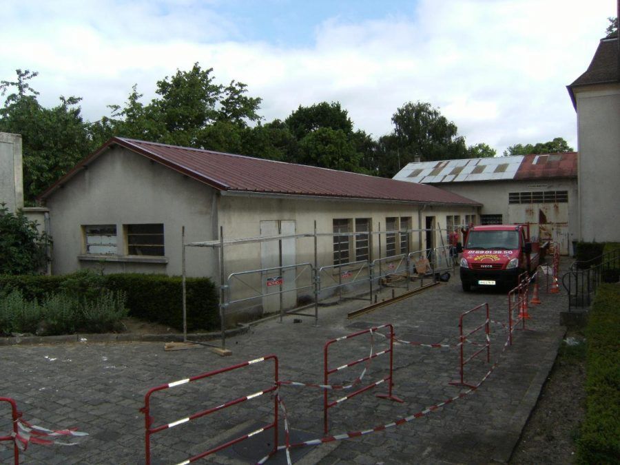 Petit bâtiment gris au toit rouge.