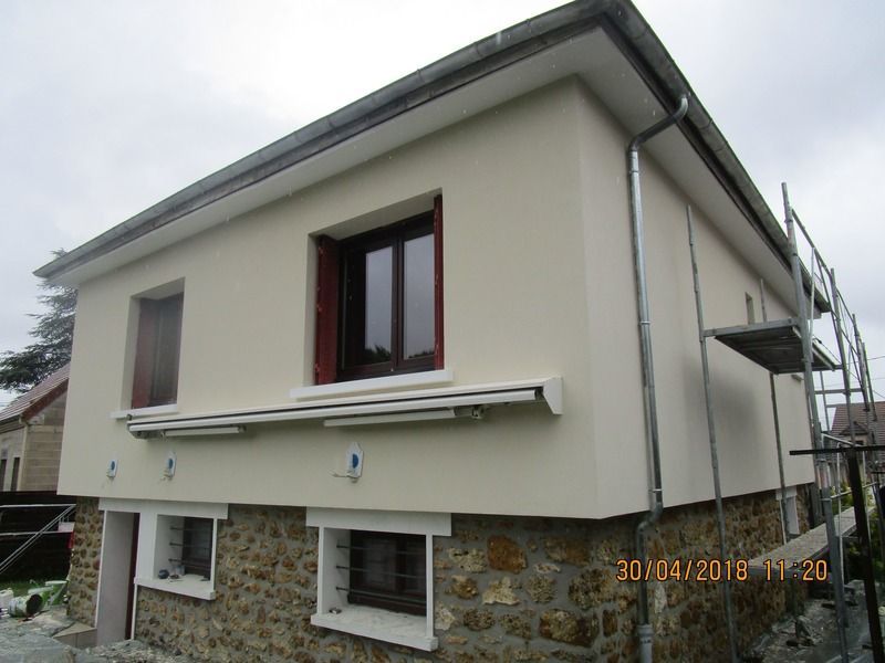 Maison à deux étages avec murs supérieurs blancs.