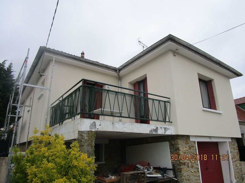Maison crème à deux étages avec balcon.