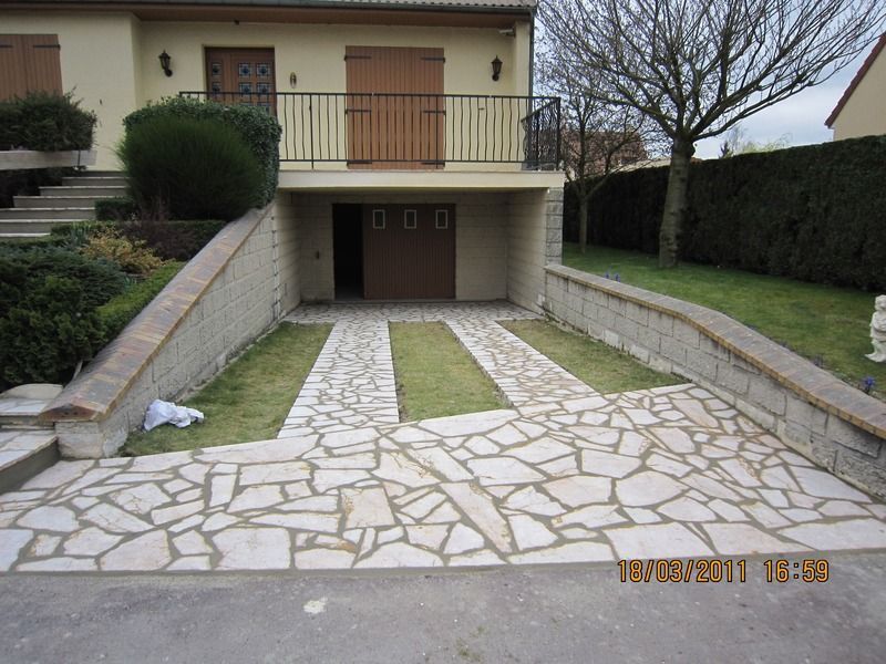 Maison avec allée, garage, balcon et pelouse avant bordée de haies.