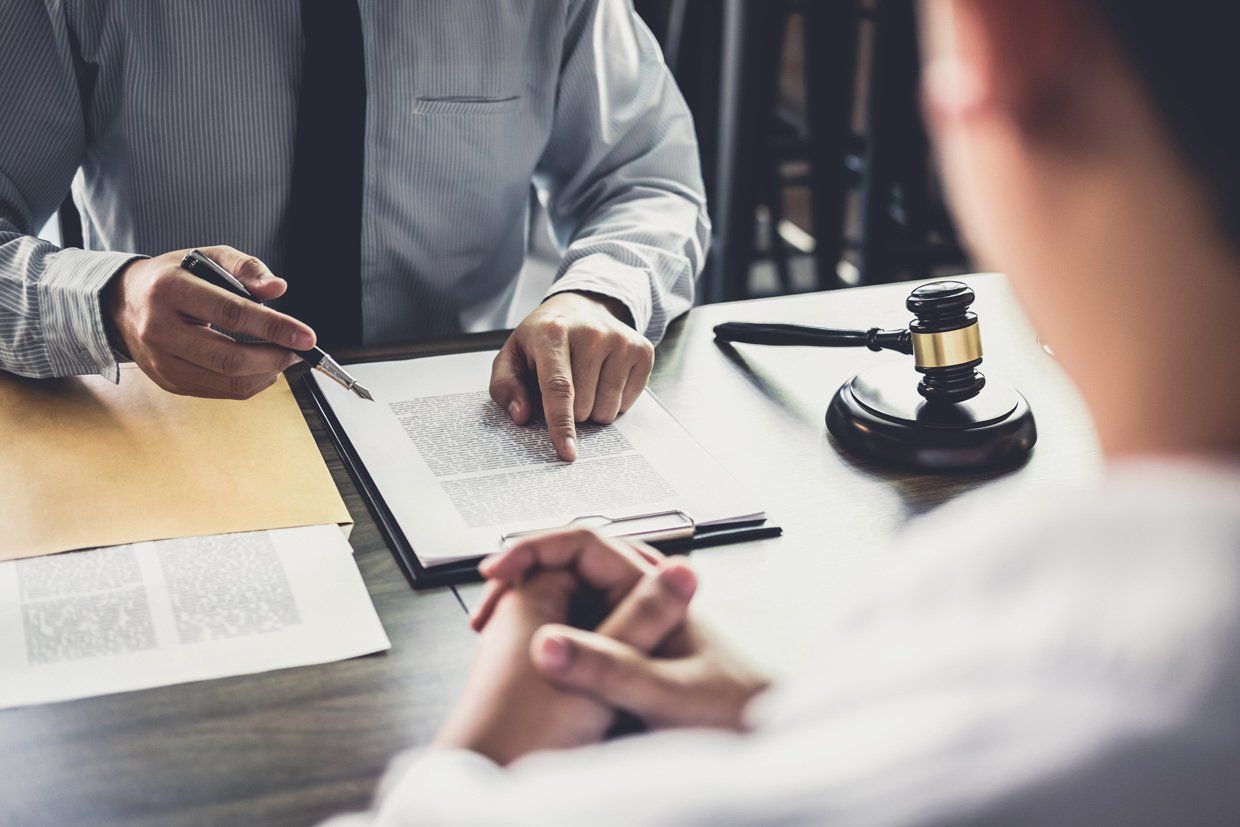 Avocat en face de son client dans son bureau lisant un document