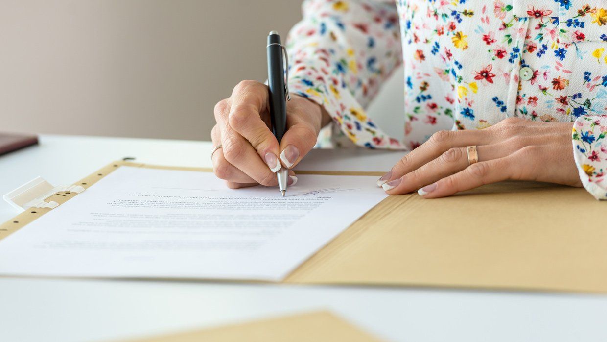 Femme en train d'écrire sur un document à un bureau