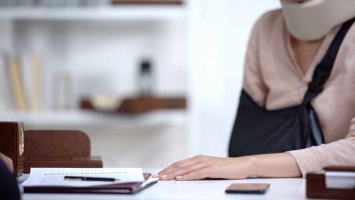 Femme avec le bras droit cassé et une minerve chez son avocat