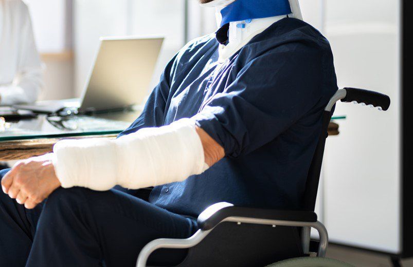 Homme plâtré et en chaise roulante devant son avocat à son bureau