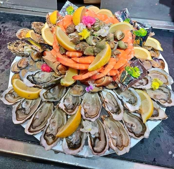 Plateau de fruits de mer rond avec des huîtres, des crevettes et des bulots
