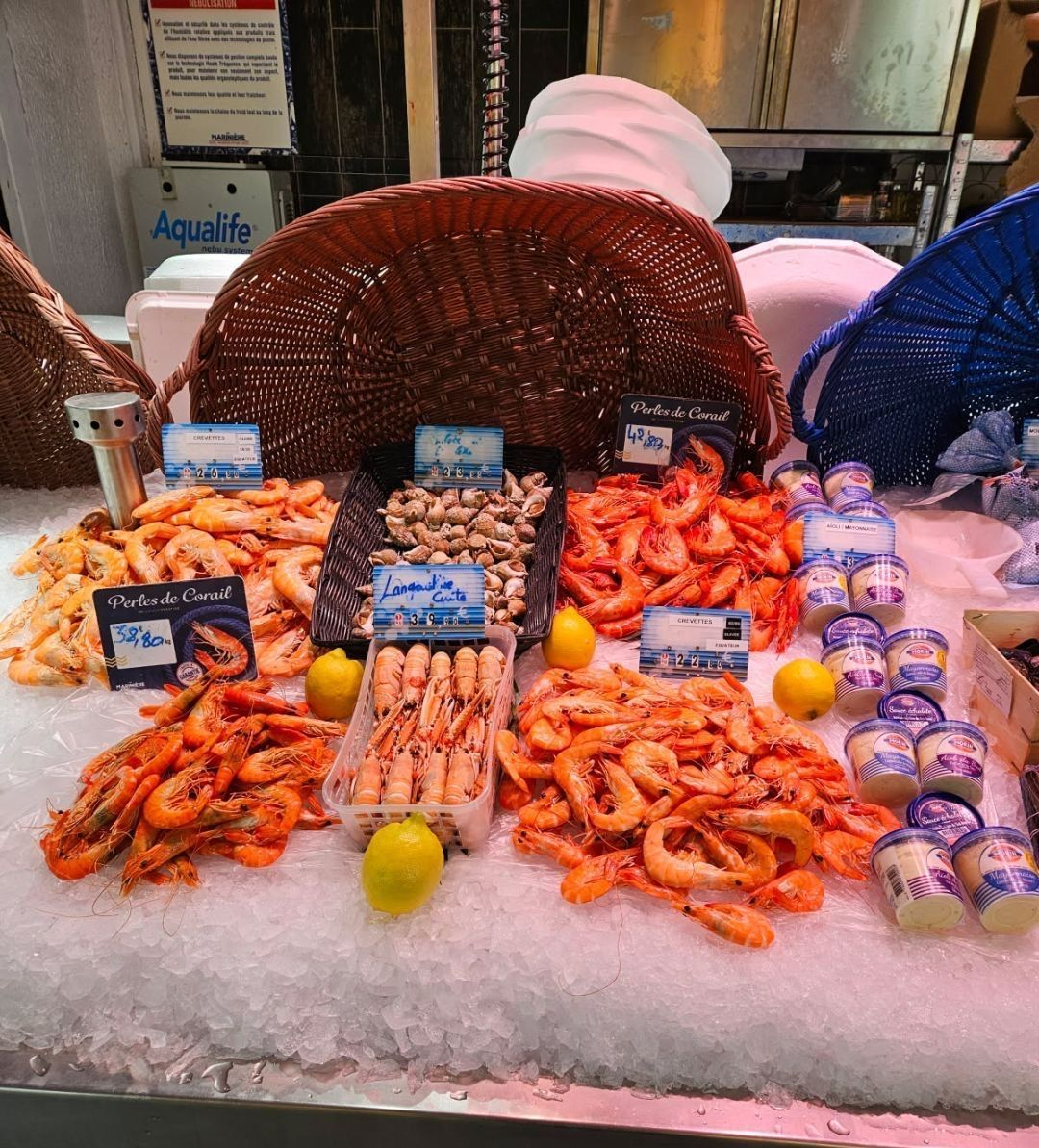 Étal de poissonnerie avec différentes crevettes et des pots de sauce