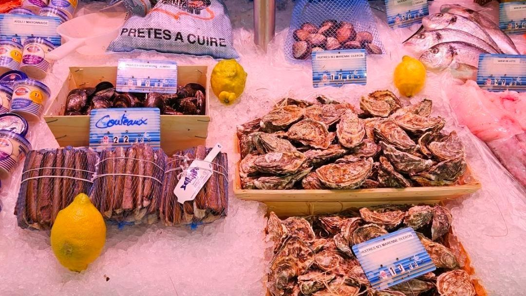 Étal de poissonnerie avec une cagette d'huîtres et de couteaux