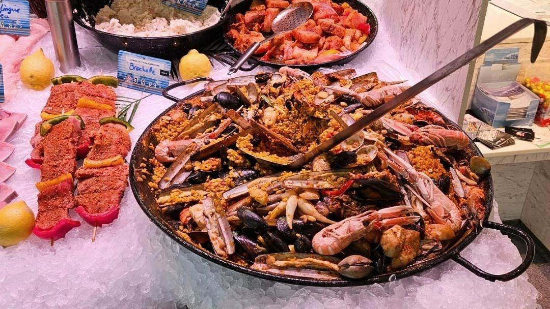 Poêlon de paella posé sur un étal de fruits de mer