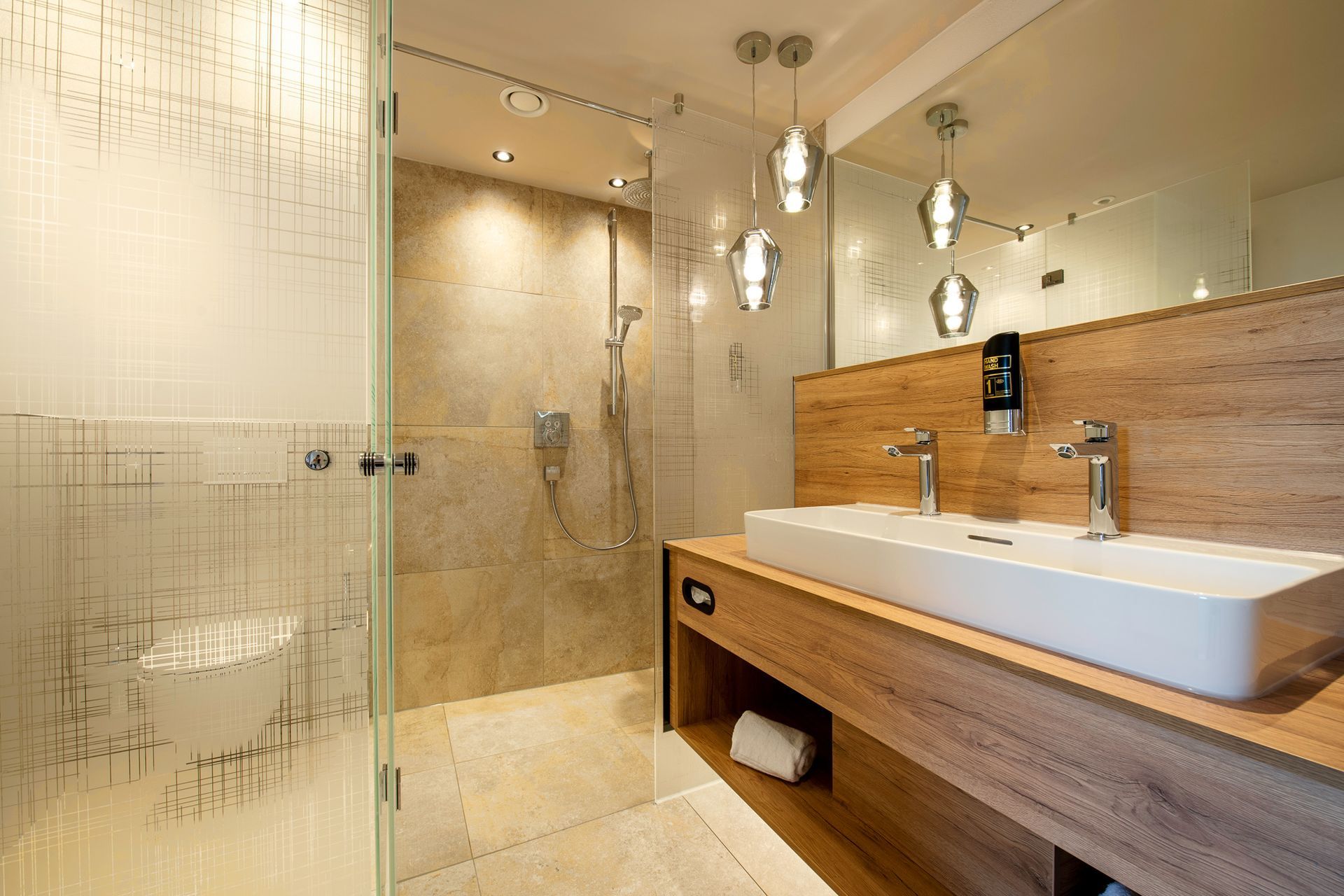 Badezimmer mit Glastrennwänden und großem Spiegel