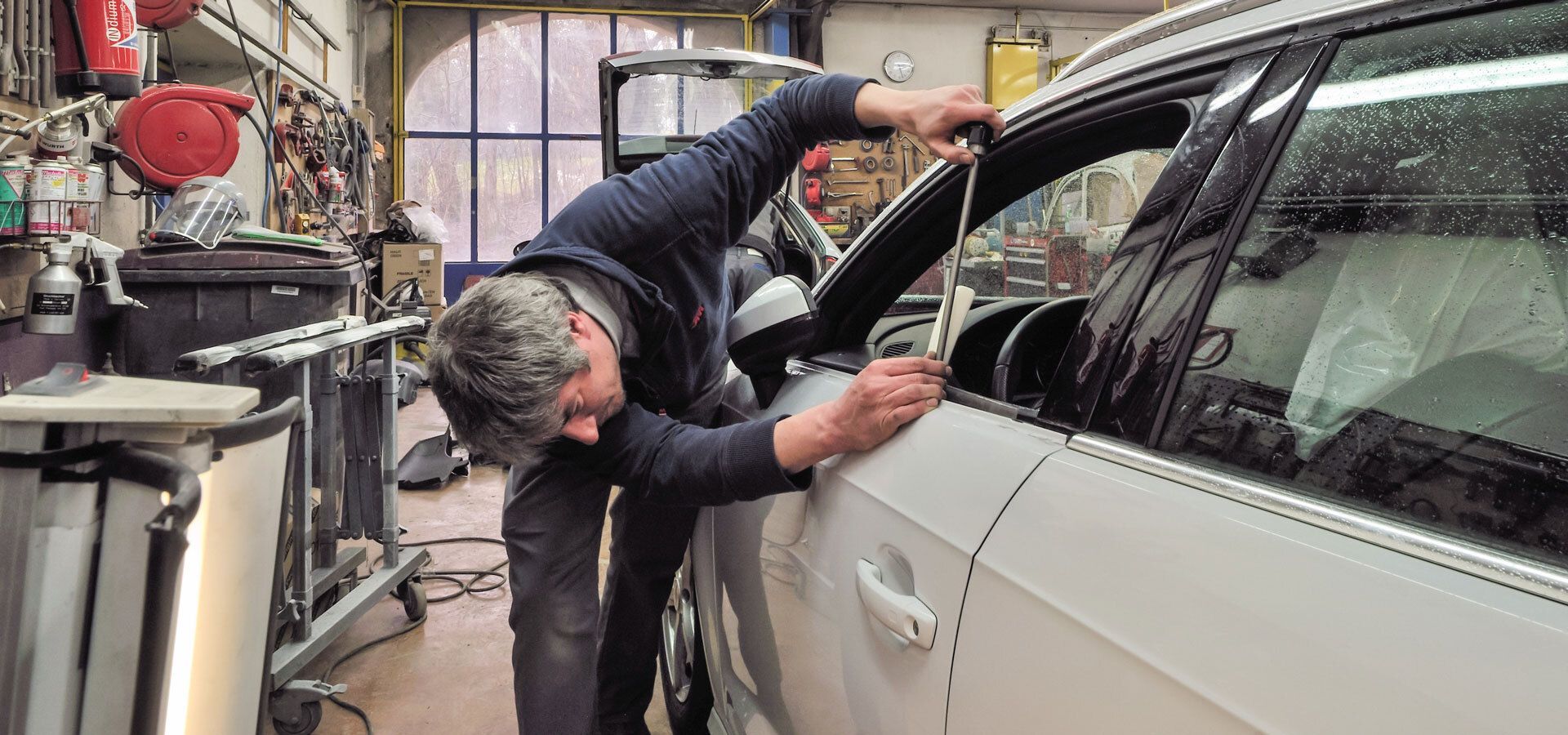 Carrossier effectuant un débosselage