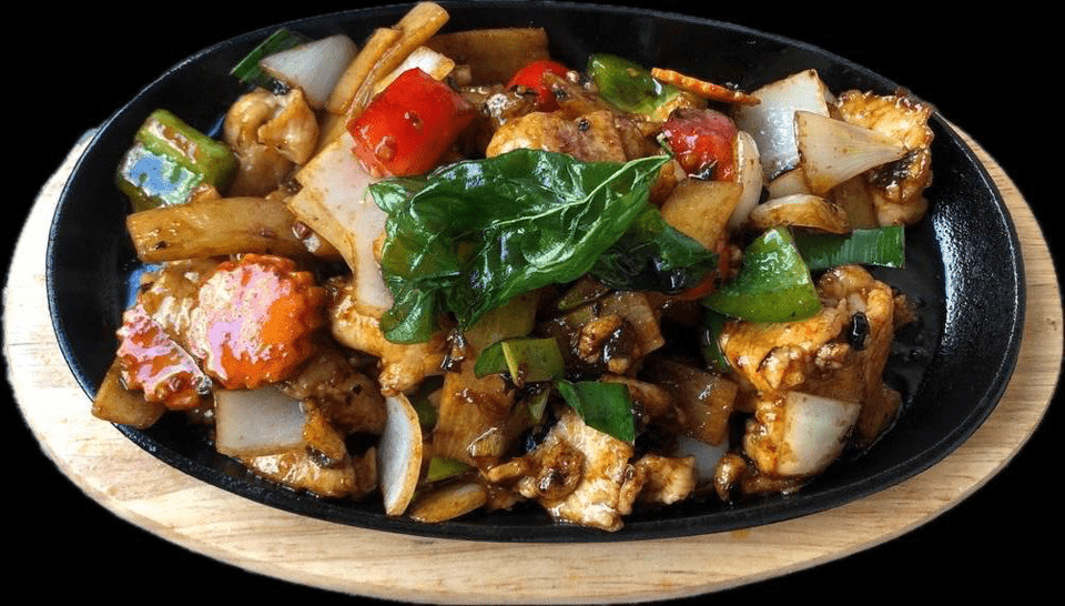 Une assiette de nourriture avec de la viande et des légumes sur une table en bois.