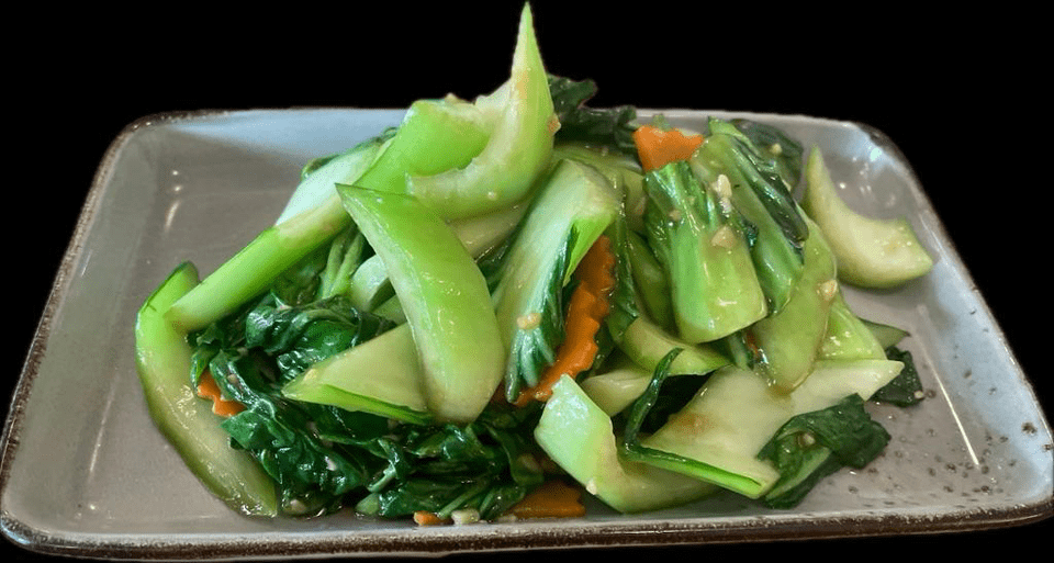 Une assiette de légumes sautés sur fond noir.