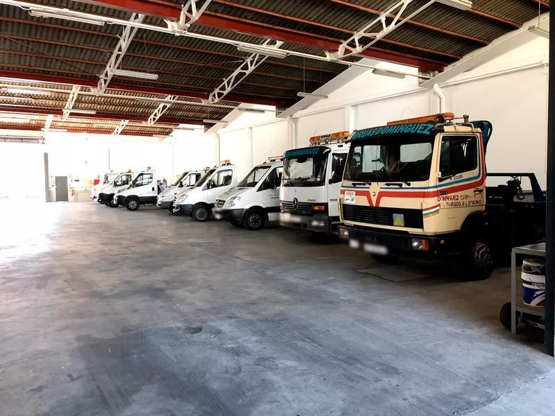 Una fila de grúas están estacionadas en un almacén.