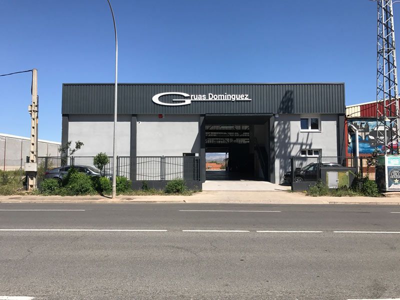 Un coche está aparcado delante de un edificio que tiene escrita la letra G.