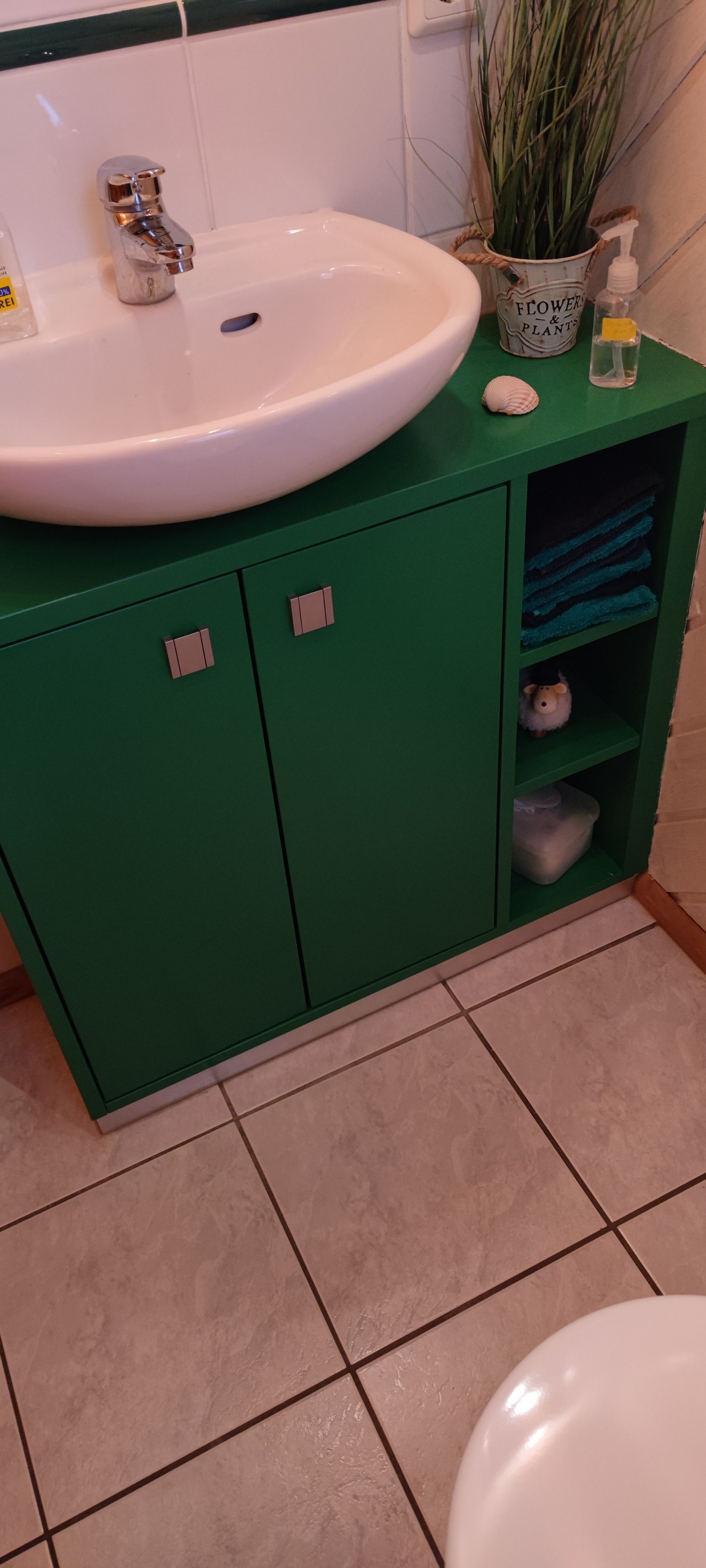 ein Badezimmer mit einem grünen Waschbecken und einer Toilette .