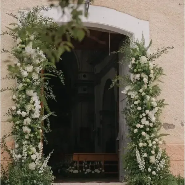 Mujer sosteniendo un ramo y un gran objeto en forma de corazón frente al escaparate de una tienda.