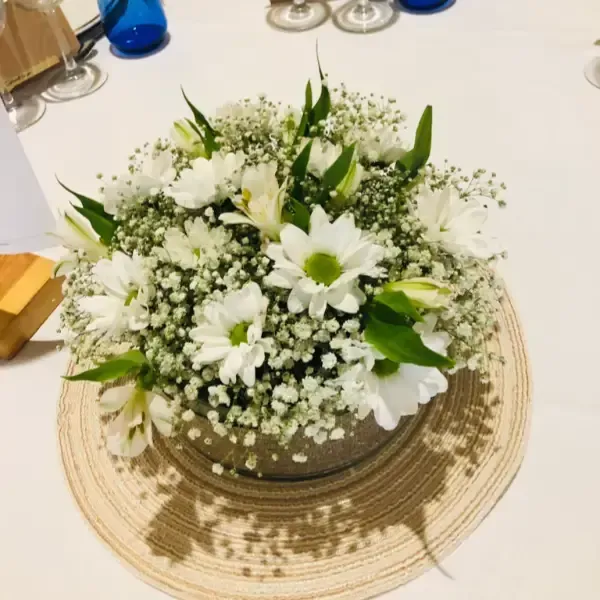Mujer sosteniendo un ramo y un gran objeto en forma de corazón frente al escaparate de una tienda.