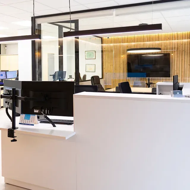 Un monitor de computadora se encuentra sobre un escritorio en una oficina.