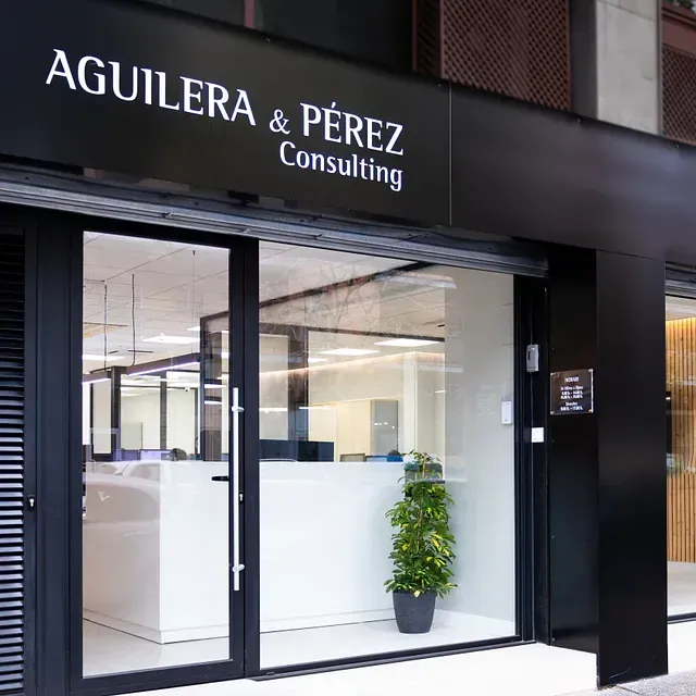 Un edificio con un cartel que dice Aguilera & Pérez Consulting.