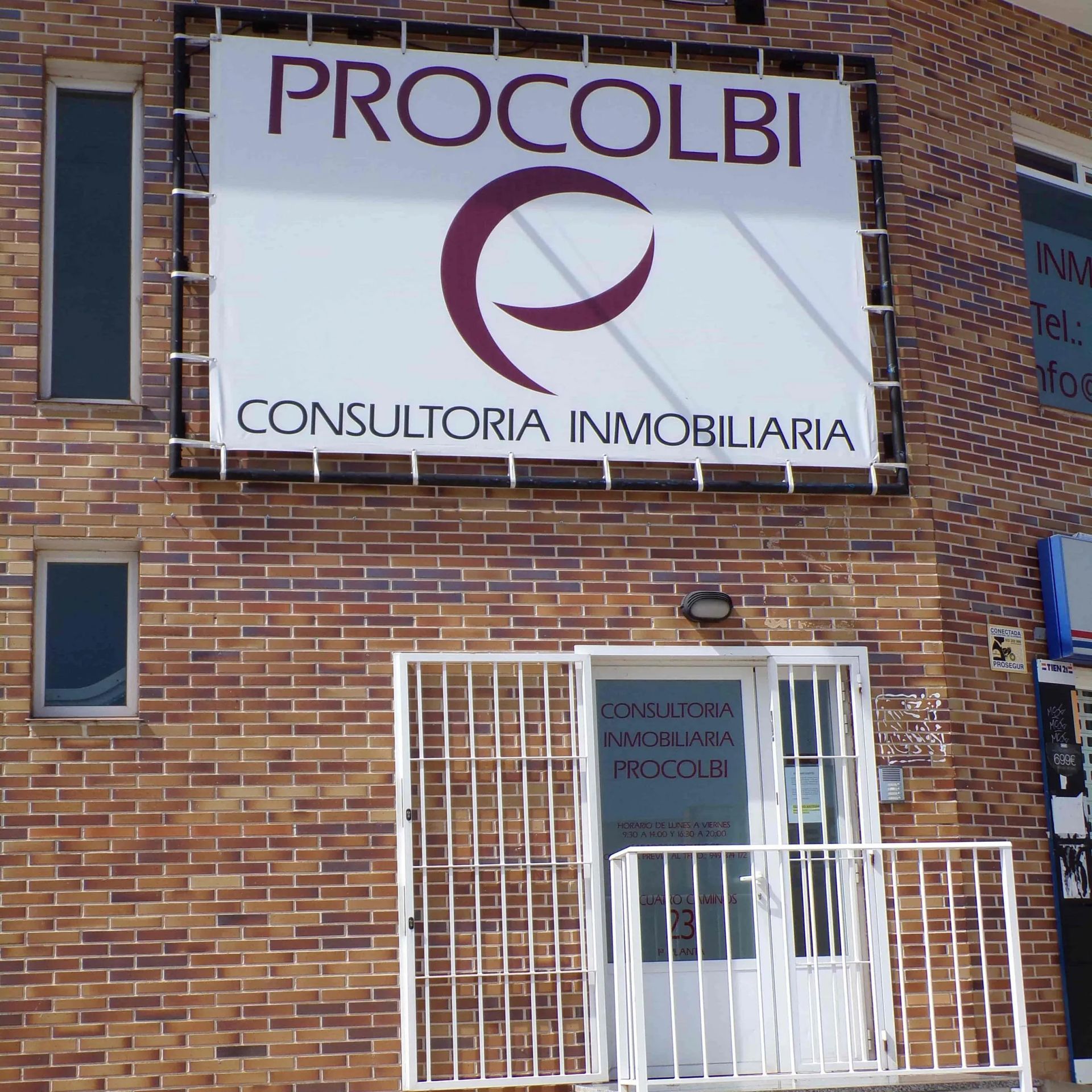 Un edificio de ladrillo con un cartel de procolbi sobre la puerta.