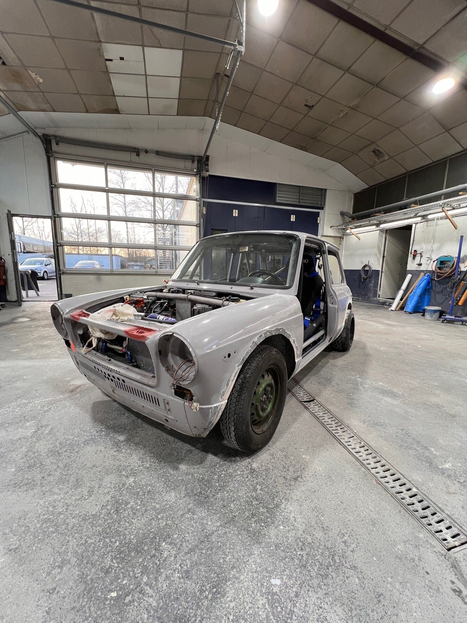 Umbau und Restauration eines alten Autos, ohne Türen und Motorhaube, abgeschliffen und Grau grundiert