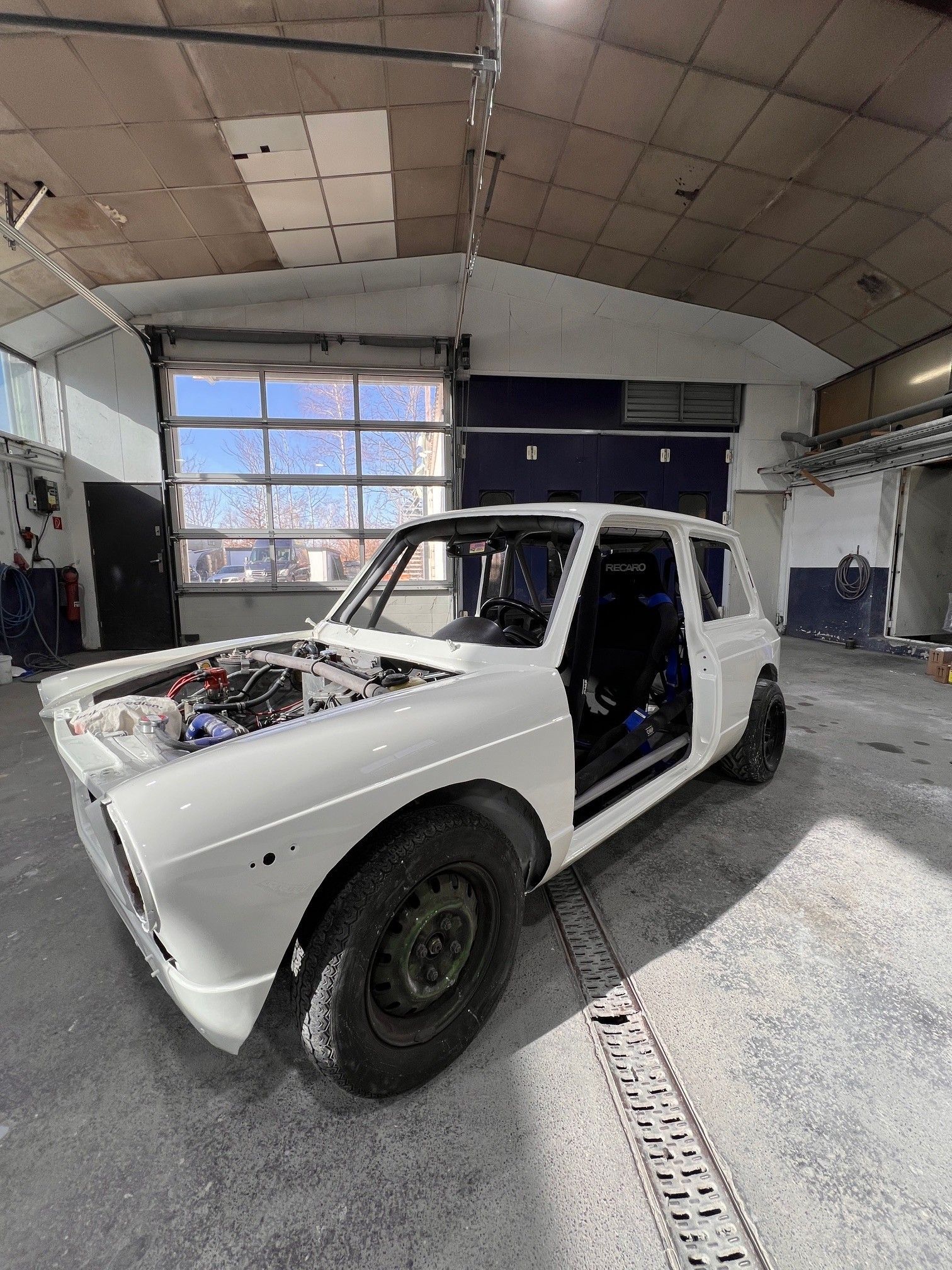 Umbau und Restauration eines alten Autos, ohne Türen und Motorhaube, weiß lackiert