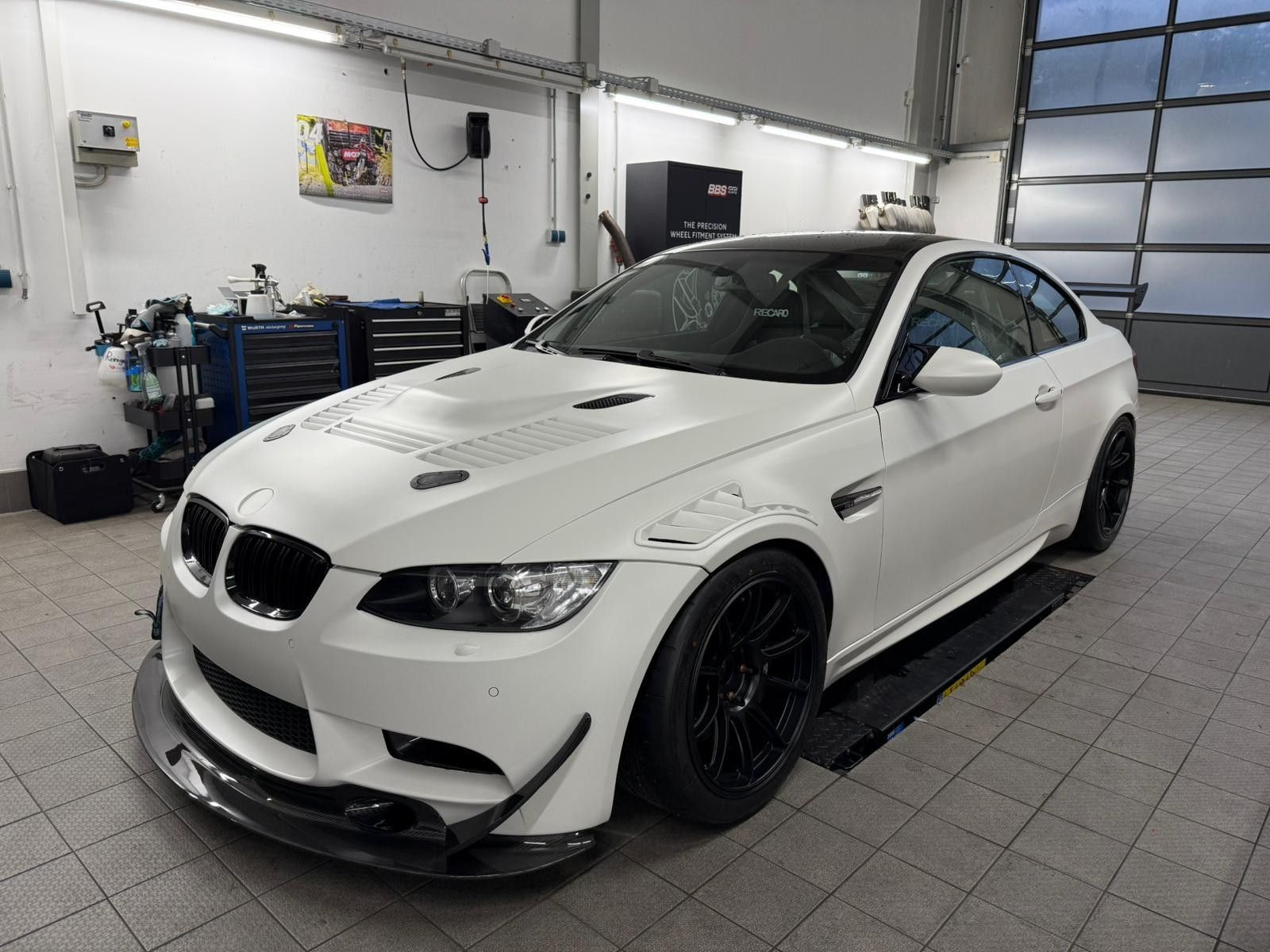 Seitliche Ansicht eines neu lackierten BMW Sportwagens in Matt Weiß