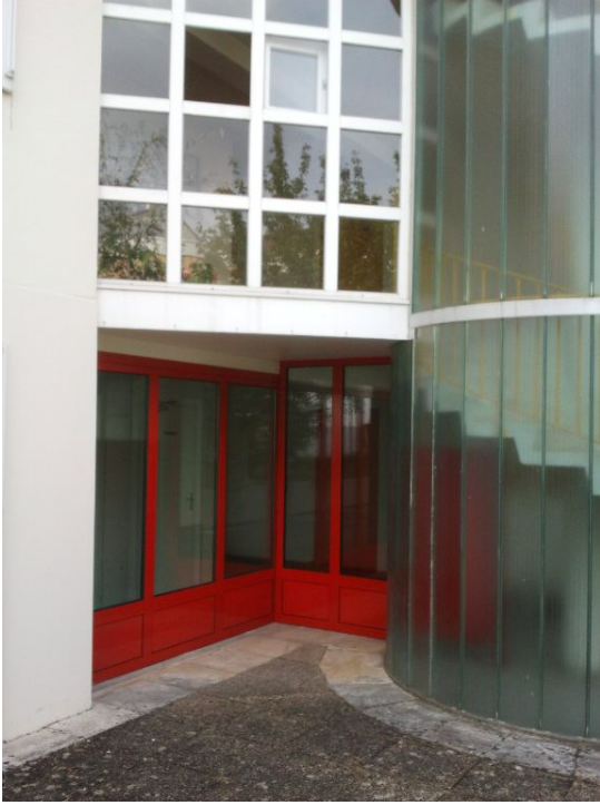 Menuiserie métallique rouge qui fait l'angle d'un bâtiment