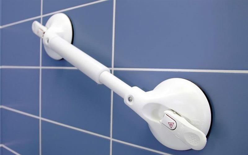 Ein weißer Griff ist an einer blau gefliesten Wand befestigt