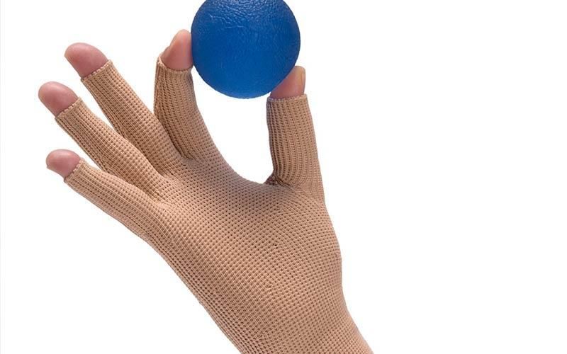 Eine Person mit Handschuh hält einen blauen Ball in der Hand.