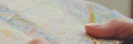 Una persona sostiene un mapa en su mano y lo señala.