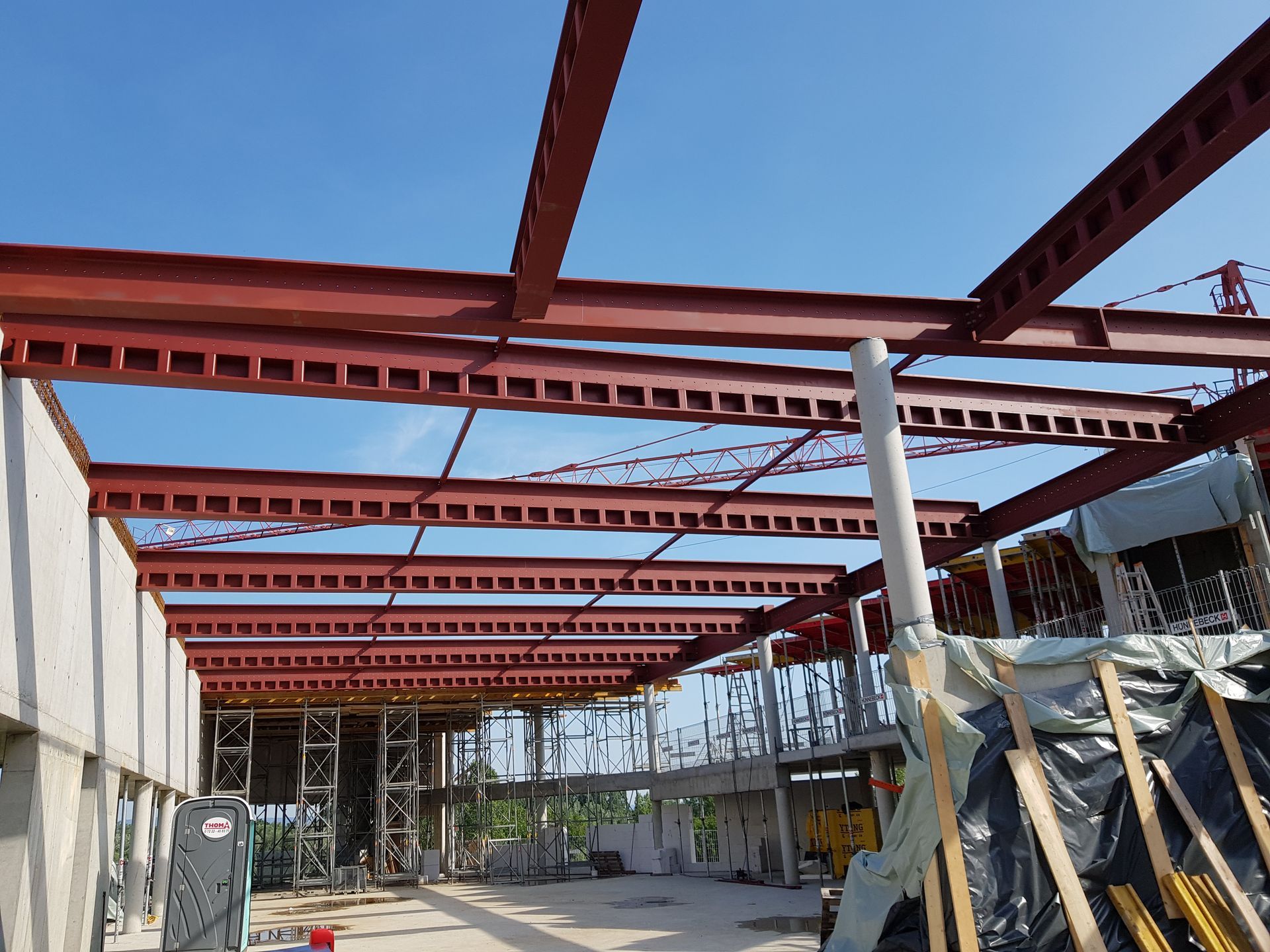 Ein Schweißer benutzt ein Schweißgerät, um Funken zu erzeugen und Metallträger im Freien zu verbinden.