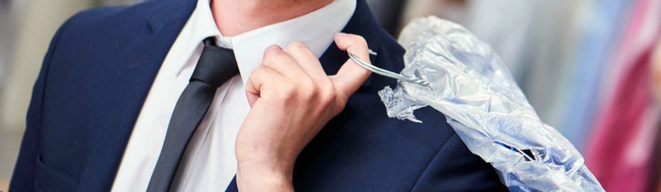 Ein Mann in Anzug und Krawatte richtet seine Krawatte.