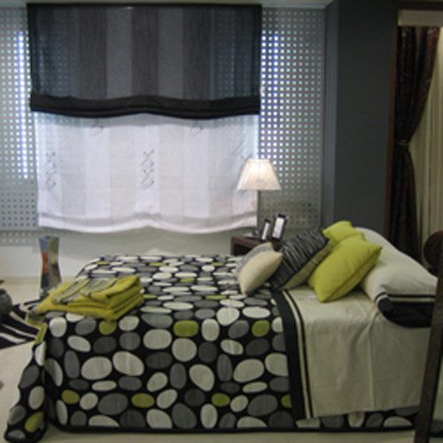 Una cama con un edredón de lunares y almohadas en un dormitorio.