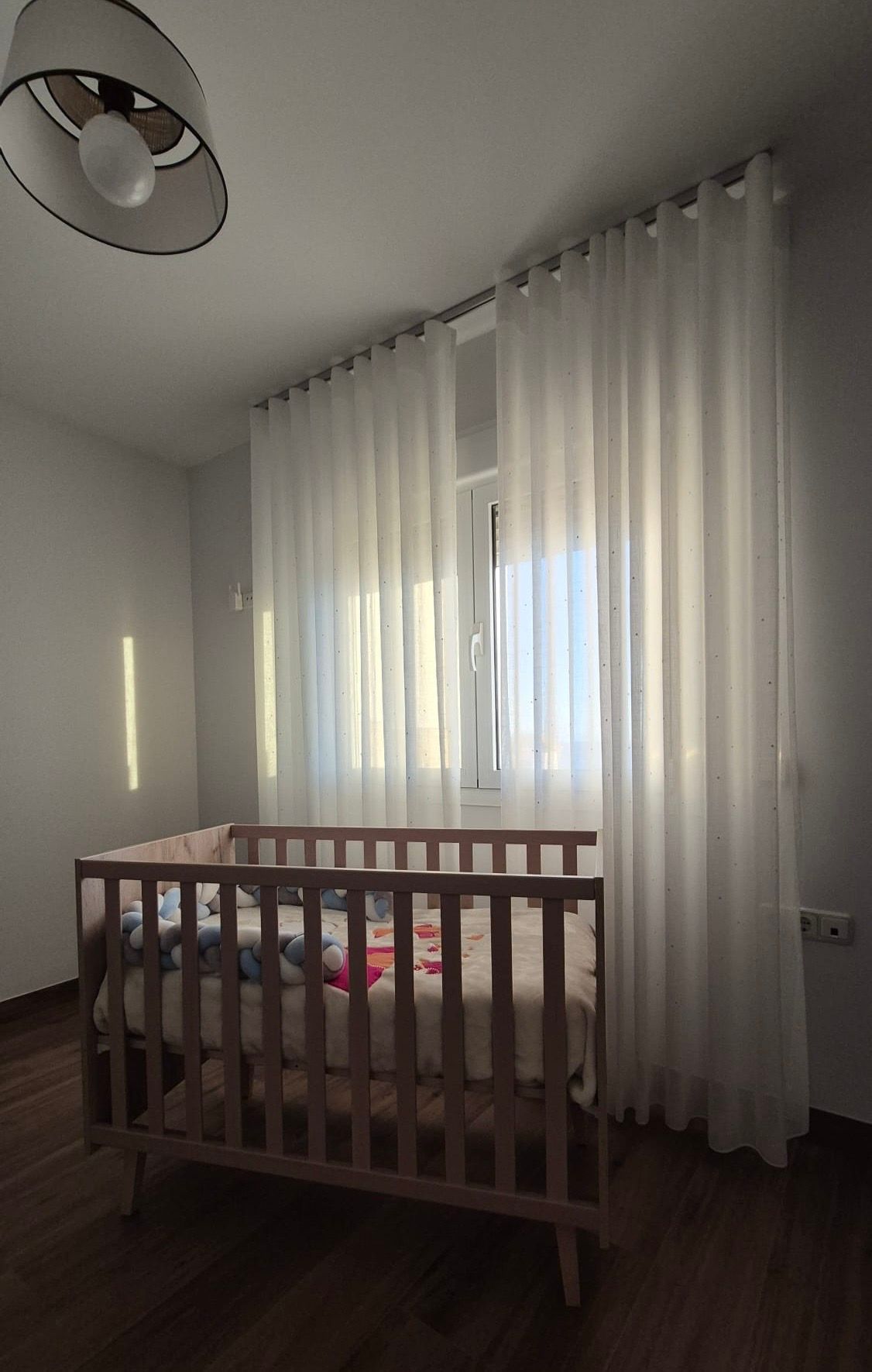 Una cama con un edredón de lunares y almohadas en un dormitorio.