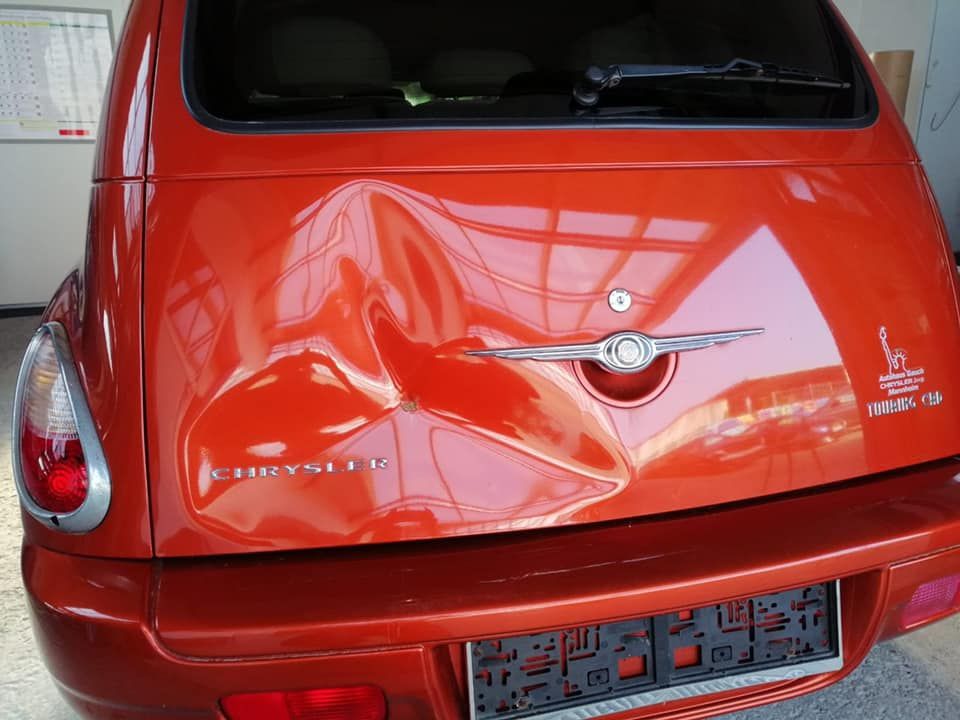 Ein rotes Chrysler-Auto mit Beule