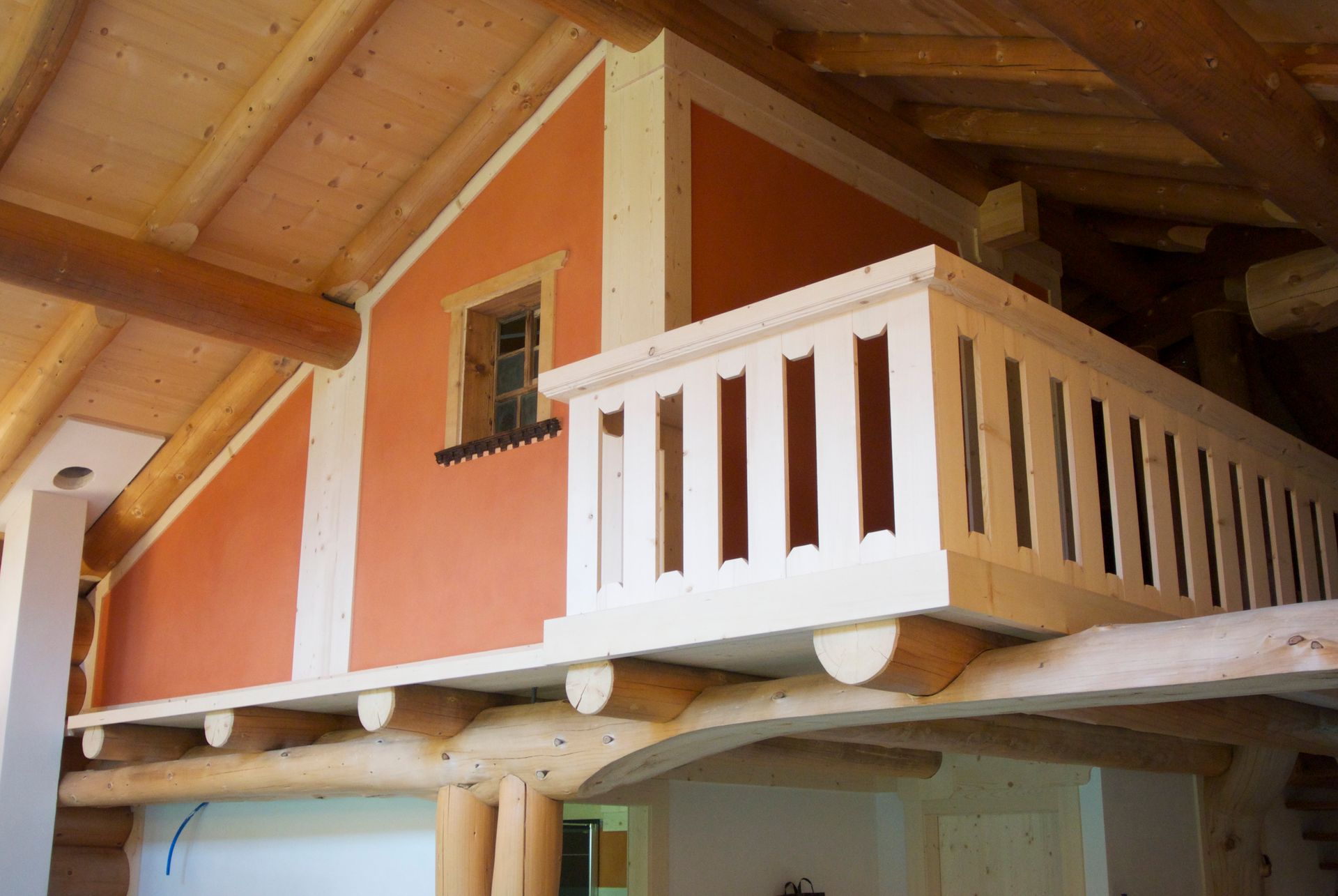 Ein Balkon in einem Holzhaus mit einem Fenster