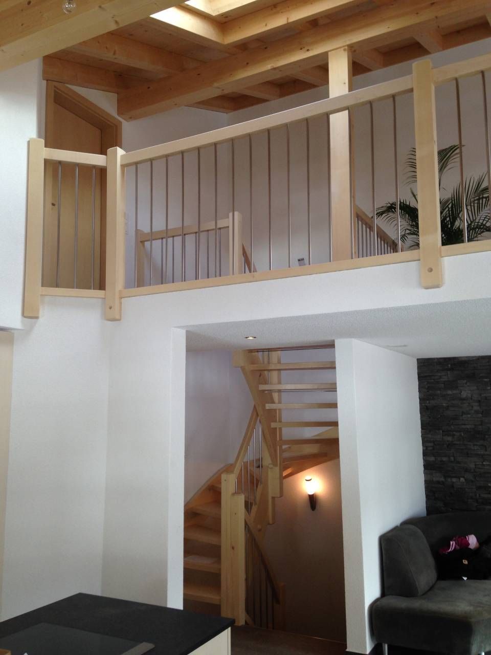 Ein Wohnzimmer mit Holzbalkon und Treppe