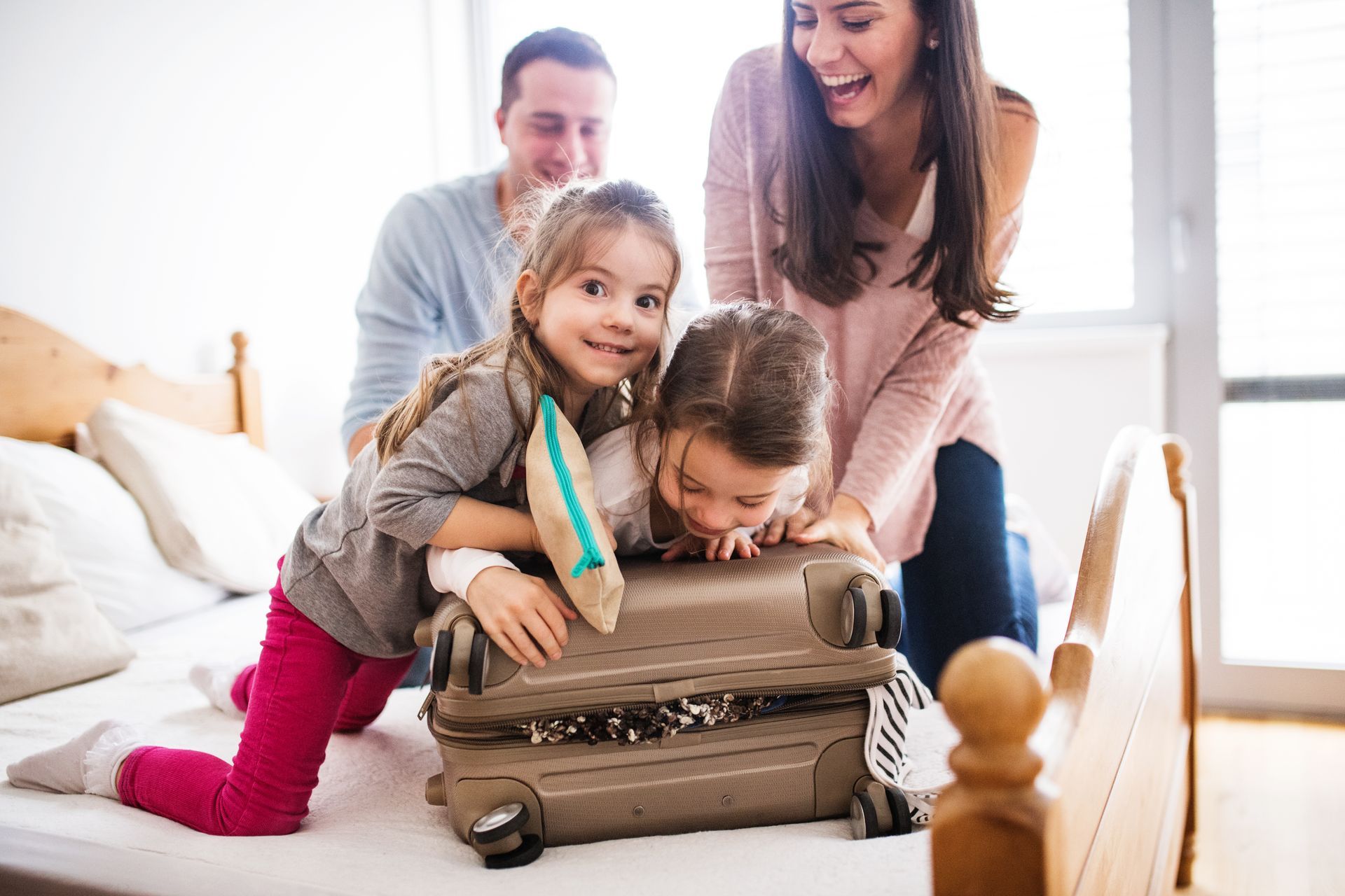 Une famille fait sa valise sur un lit.