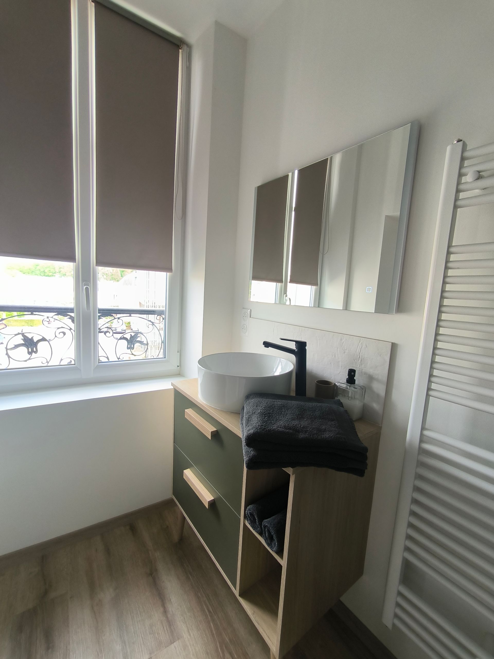 Meuble-lavabo avec lavabo, miroir, sèche-serviettes et fenêtre avec store enrouleur