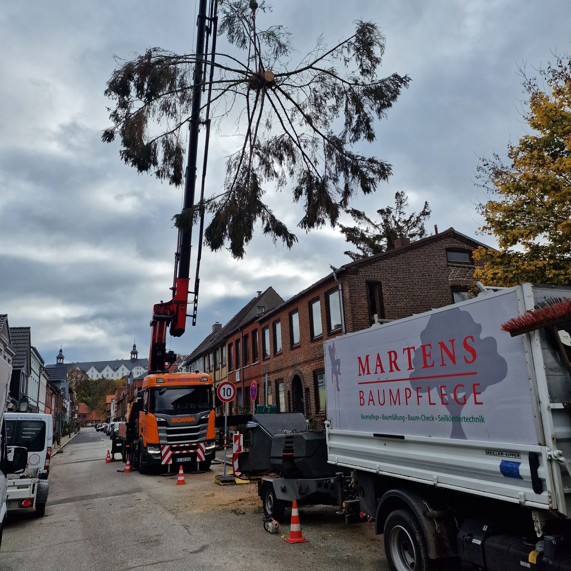 Ein weißer LKW mit einem roten Schild mit der Aufschrift „Martens Baumpflege“