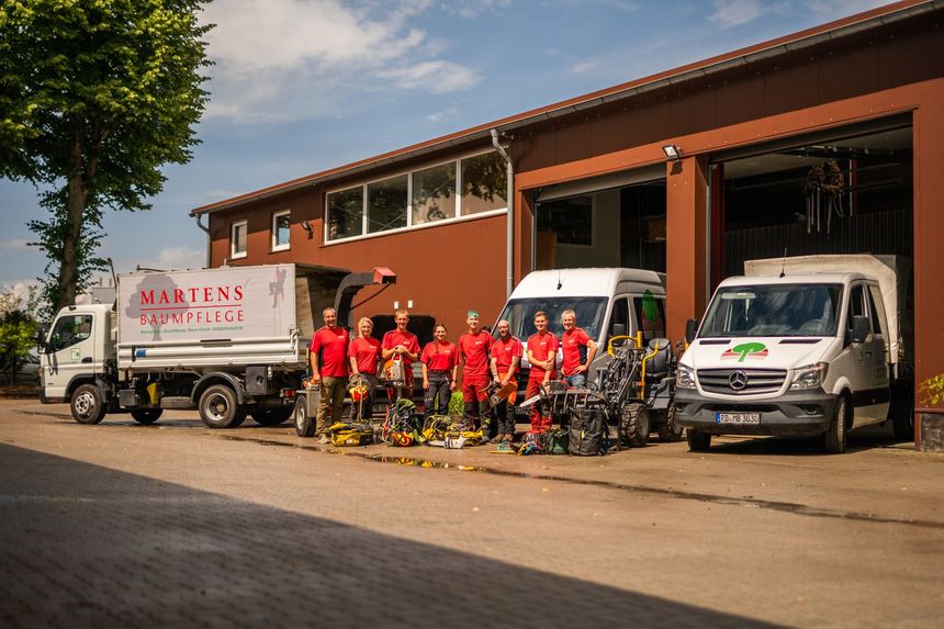 Eine Gruppe Männer posiert vor einem Lastwagen für ein Foto.