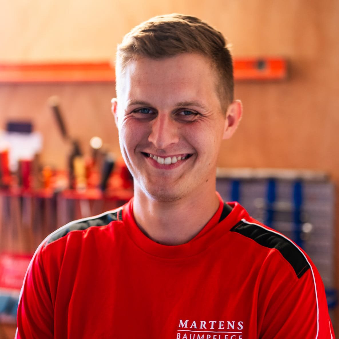 Ein Mann trägt ein rotes Hemd mit der Aufschrift „Martens“ darauf.