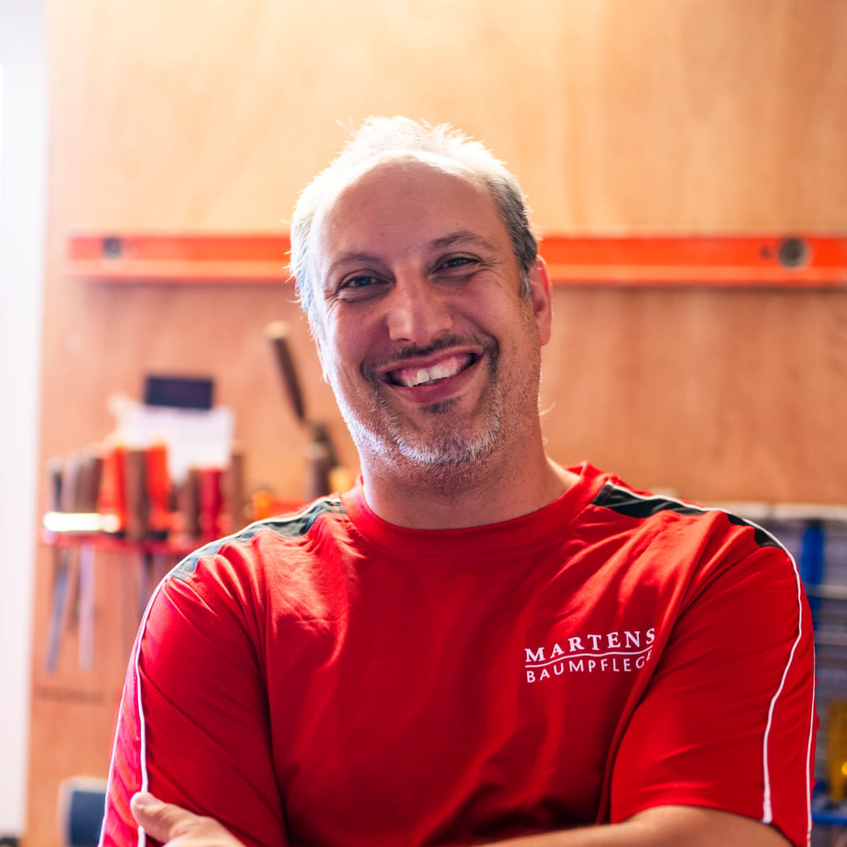 Ein Mann trägt ein rotes Hemd mit der Aufschrift „Martens“ darauf