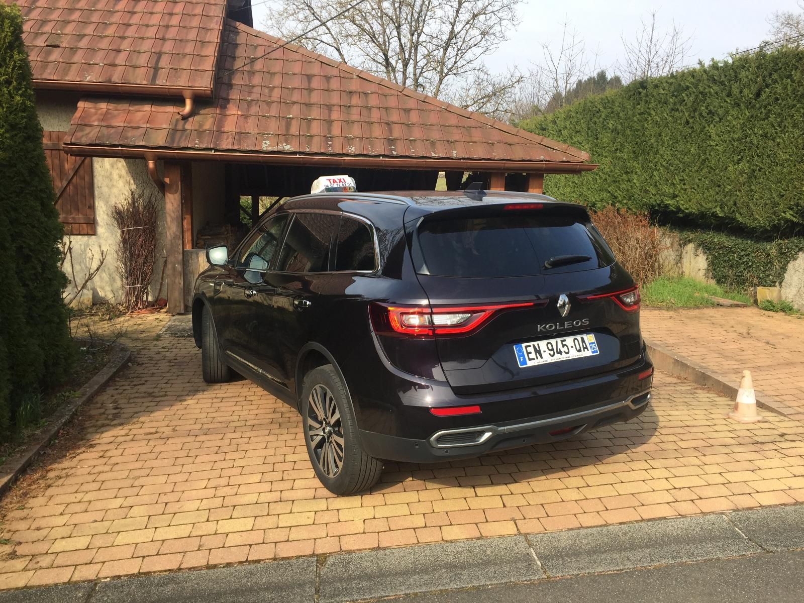 Taxi noir garé devant une maison