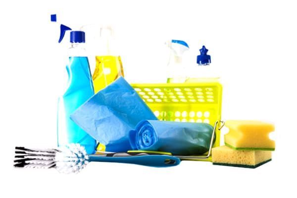 Fournitures de nettoyage : vaporisateurs, éponges, chiffons bleus, brosse à récurer et un panier.